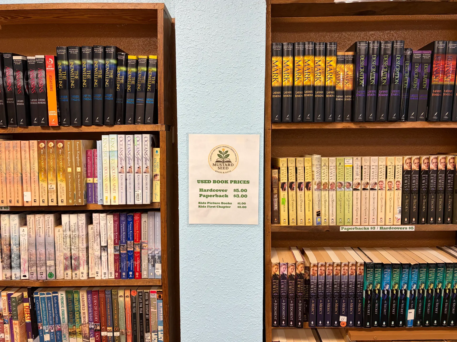 Used book price sign in the shop: hardcover $5, paperback $3, kids picture books $1