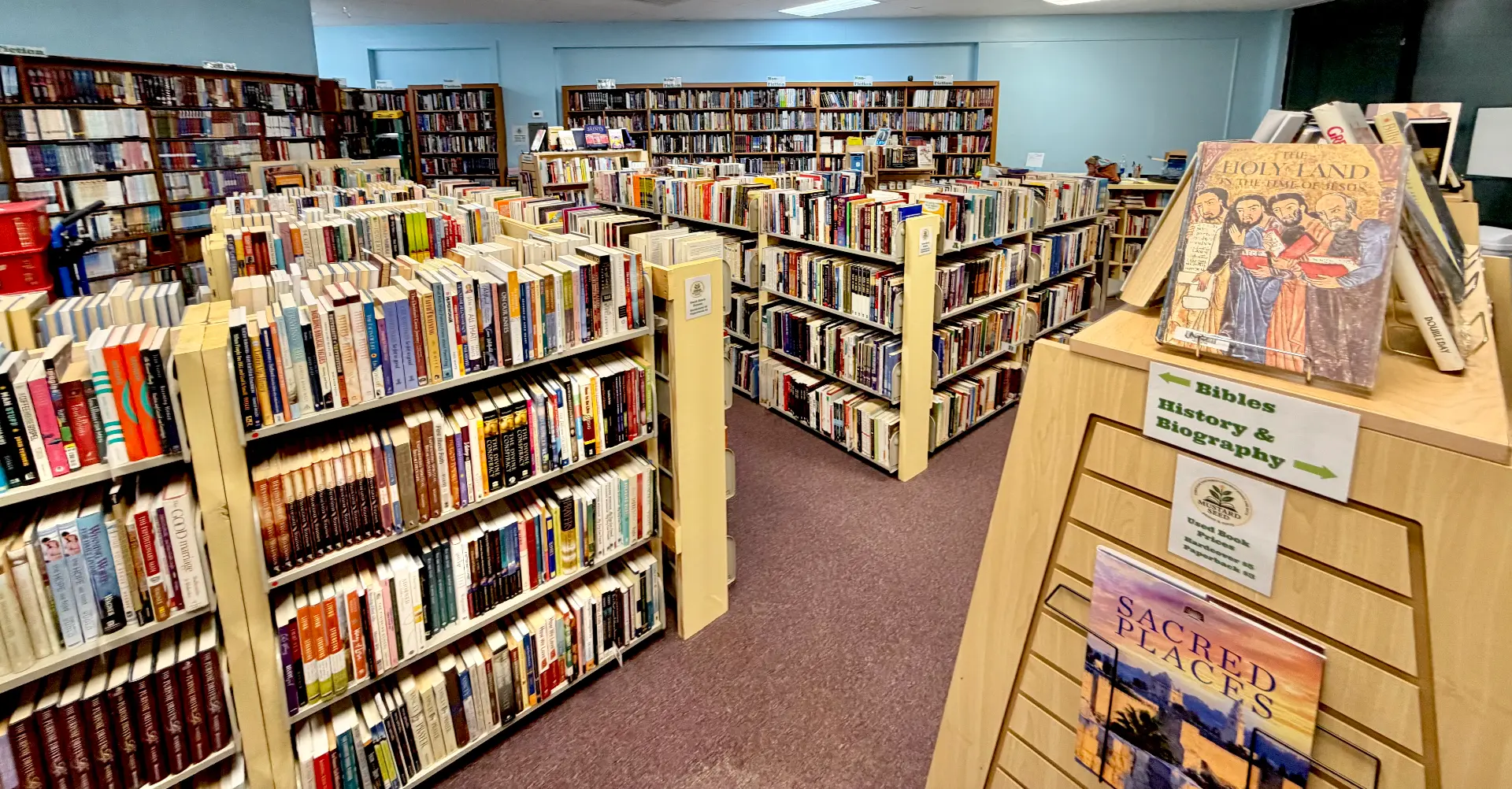 Overview of non-fiction shelves with Bibles and history signage