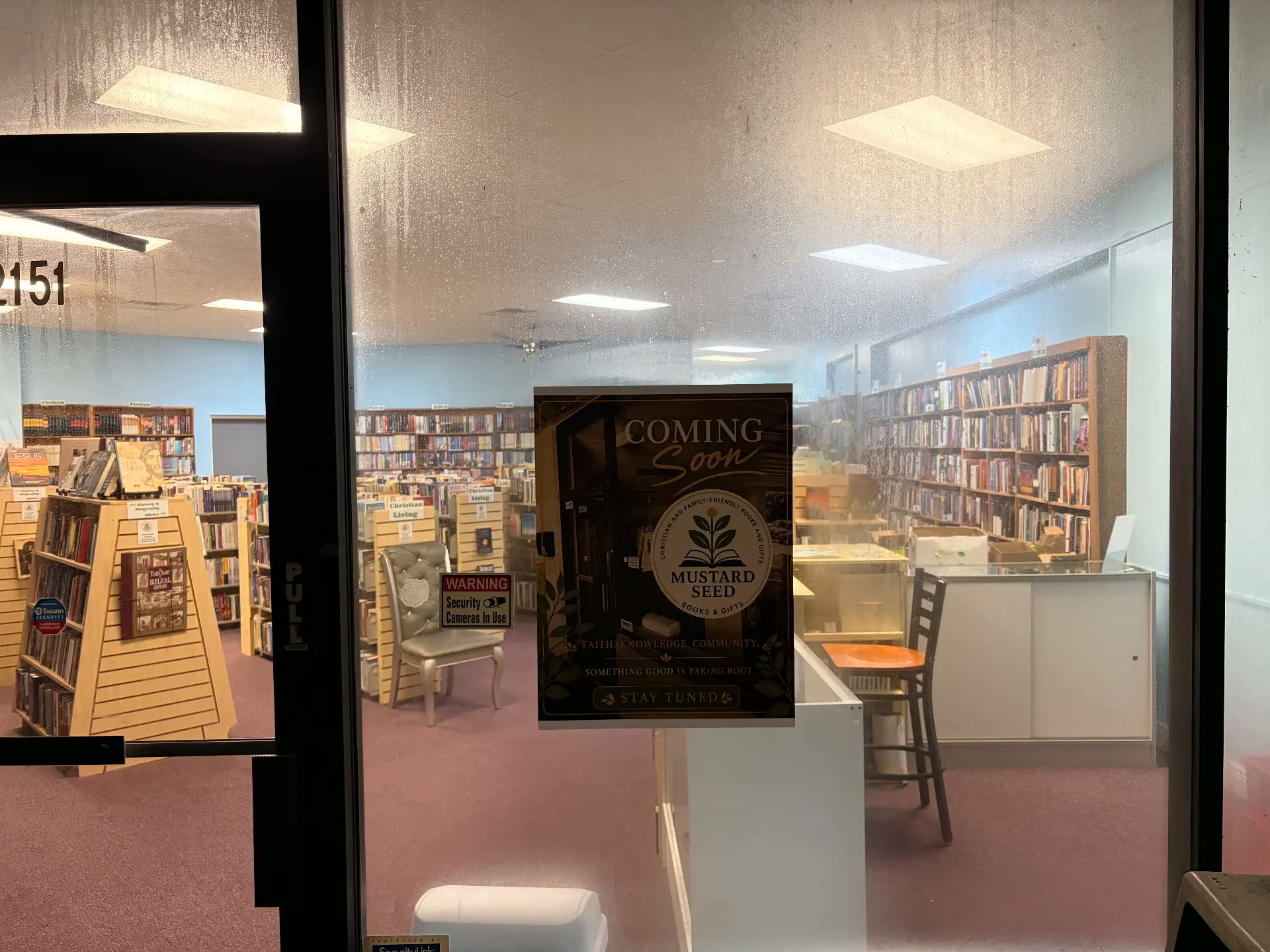 Mustard Seed Books & Gifts storefront with Coming Soon poster in the window