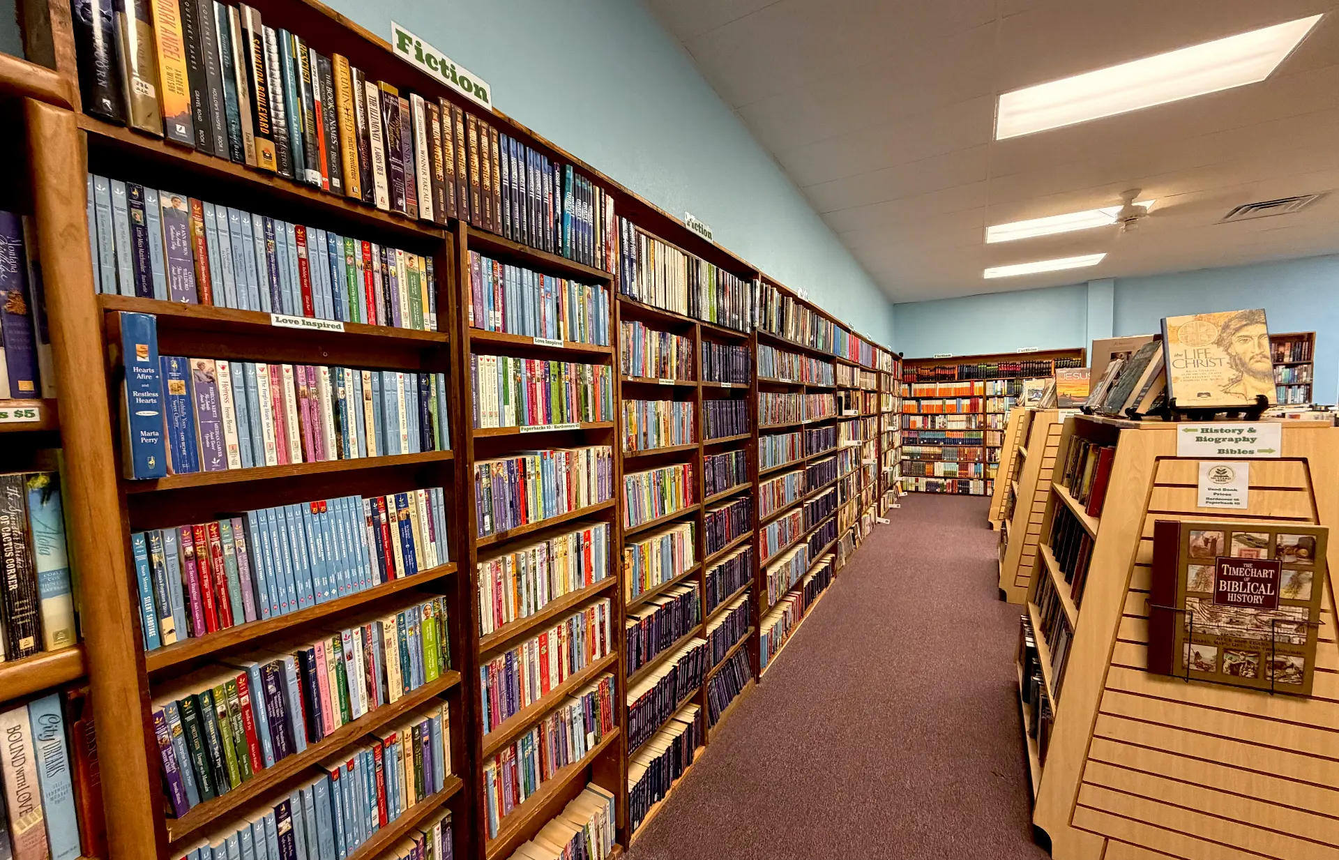Long fiction aisle with shelves of used Christian fiction